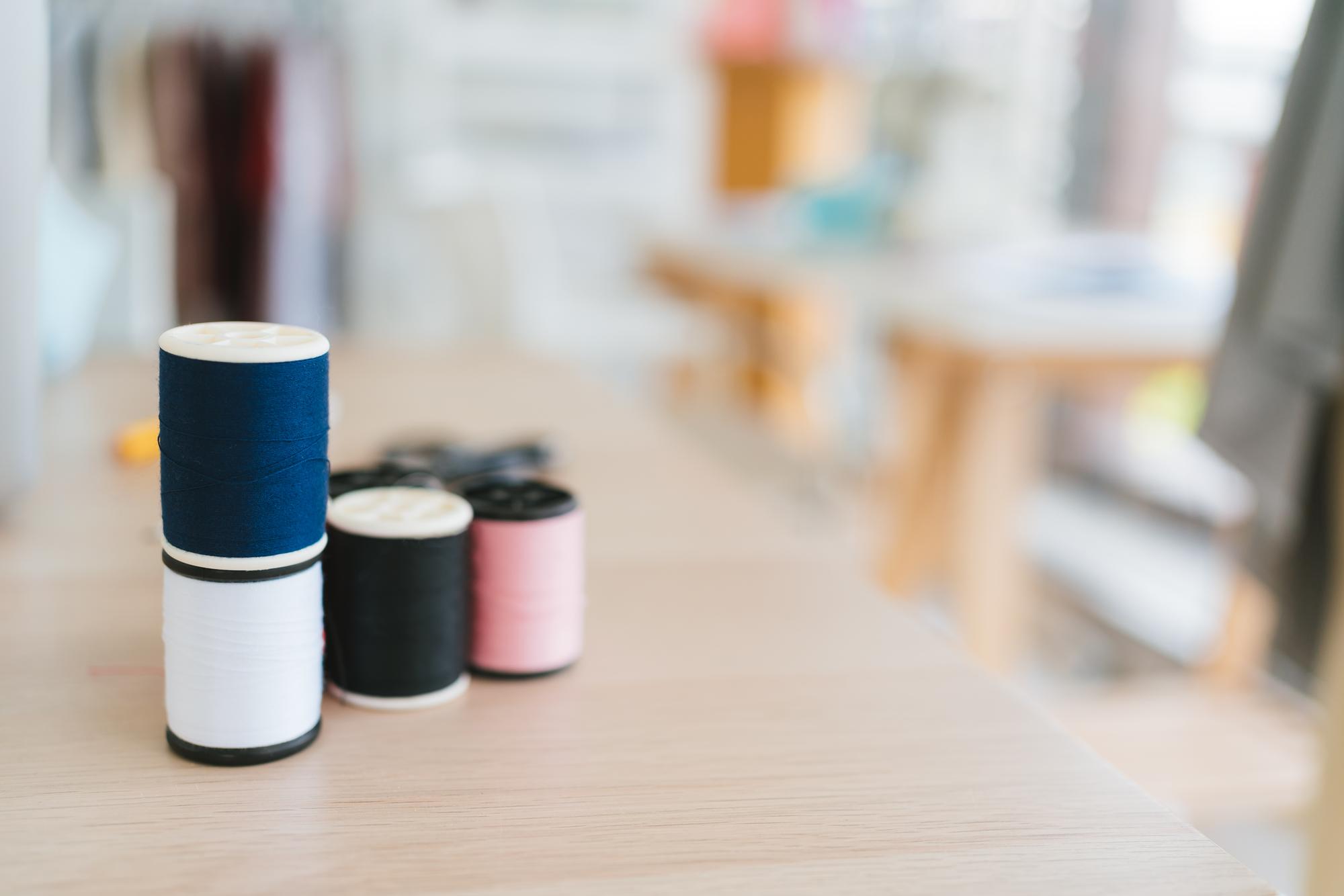 Workbench with thread spools and embroidered sample